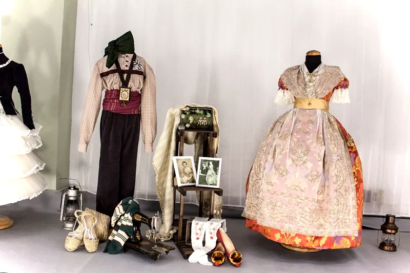 Trajes y complementos de indumentaria valenciana con zapatos y abanicos